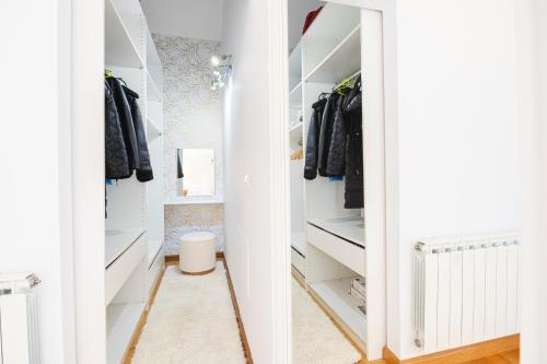 a walk in closet with white cabinets and a mirror at Casa Buena Vista in Candás
