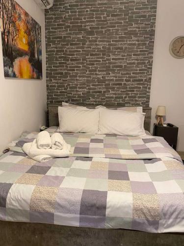 a bedroom with a large bed with a brick wall at Central & Riverfront Room 1 in Edessa