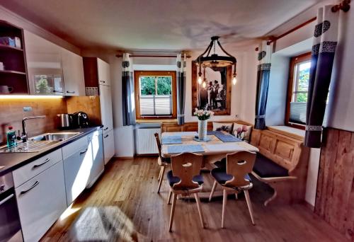 eine Küche mit einem Tisch, Stühlen und einem Waschbecken in der Unterkunft Apartment Bergblick, 3 Schlafzimmer, 2 Badezimmer in Kirchberg in Tirol