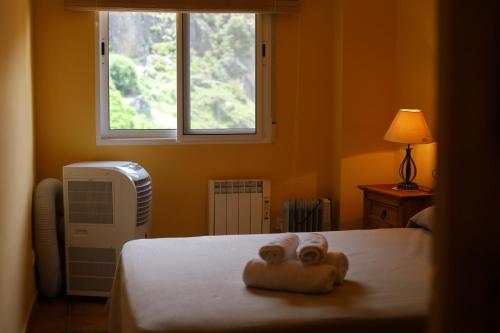 1 dormitorio con 1 cama con 2 toallas en DLJ Sierra de Cazorla Parking Gratis, en La Iruela