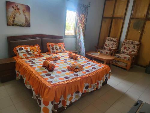 ein Schlafzimmer mit einem Bett mit zwei Teddybären darauf in der Unterkunft Résidence la Grâce Benkadi in Bobo-Dioulasso