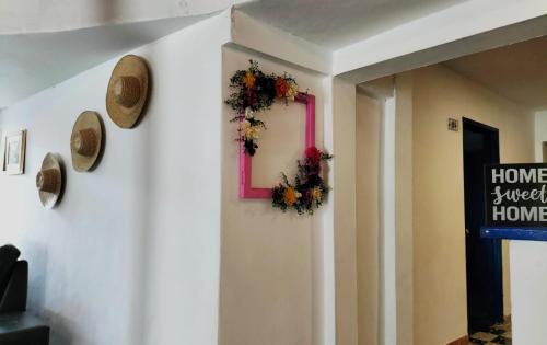 una habitación con un marco rosa y flores en la pared en Hotel Palma Azul Beach, en Coveñas