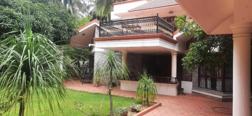 a house with a balcony and a courtyard at Spring Valley Villa in Bengaluru