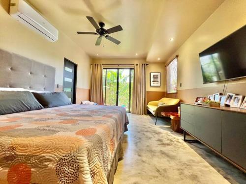 Schlafzimmer mit einem Bett und einem Deckenventilator in der Unterkunft Villa Gucci Luxury Manuel Antonio w Pool in Manuel Antonio