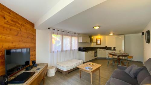 a living room with a couch and a table at L'Intermède & En toute amitié - Les Gites de l'Argile in Faucon-de-Barcelonnette
