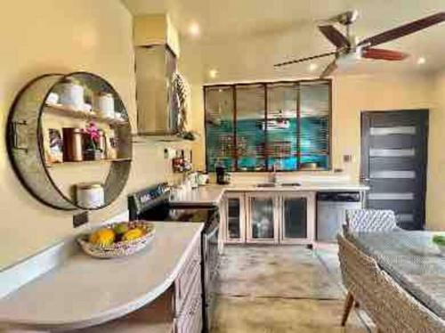 eine große Küche mit einer Theke und einem Spiegel in der Unterkunft Villa Gucci Luxury Manuel Antonio w Pool in Manuel Antonio