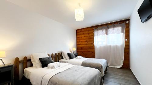 a bedroom with two beds and a window at L'Intermède & En toute amitié - Les Gites de l'Argile in Faucon-de-Barcelonnette