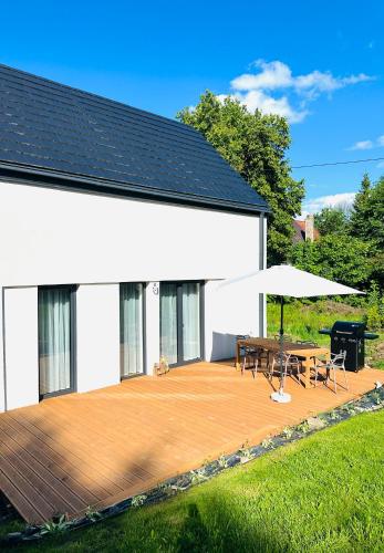a house with a wooden deck with a table and a grill at MINIMAL. Dom całoroczny w górach in Duszniki Zdrój
