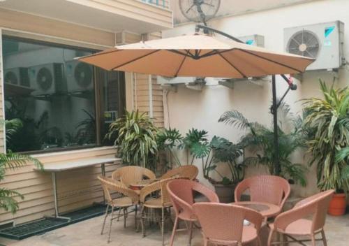 a table and chairs and an umbrella on a patio at UDS Villa - Next to VFS, Walking to Connaught Place in New Delhi