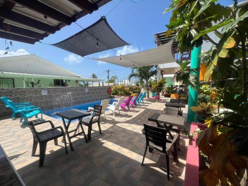 un patio con tavoli e sedie accanto alla piscina di Posada Ashanty a Providencia