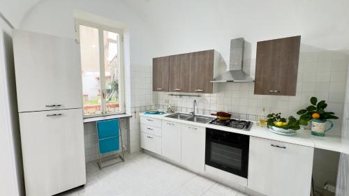 een witte keuken met een wastafel en een fornuis bij Mira Mila in Massa Lubrense