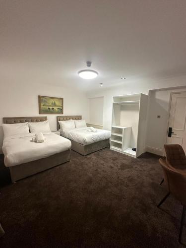 ein Hotelzimmer mit 2 Betten und einem Schreibtisch in der Unterkunft The Chapter Hotels - Mayfair Residences in London