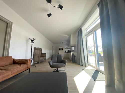 a living room with a couch and a chair at Vakantiehuis Buitengewoon in Beers