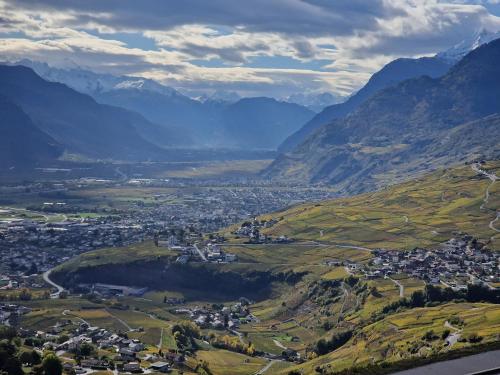 an aerial view of a town in a valley with mountains at Bella Flocon appartements min 2 Nights Special weekly and monthly prices in Savièse