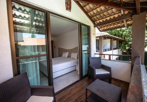 a balcony with a room with a bed and a chair at Duro Beach Garden Hotel in Cumbuco