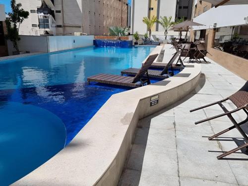 a swimming pool with two lounge chairs and a swimming pool at Apart-hotel 36m² Varanda Vista Mar no Cabo Branco in João Pessoa