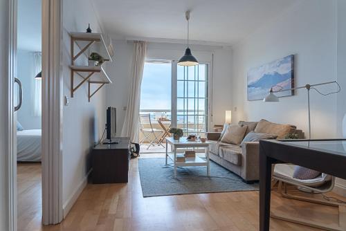 a living room with a couch and a table with a television at AT Tino Casal in Almería