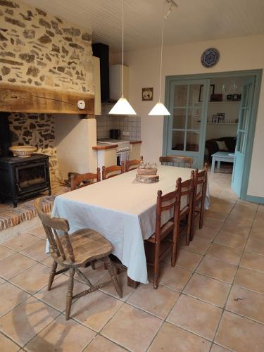 une cuisine et une salle à manger avec une table et des chaises dans l'établissement La Maison Bleue - Domaine de la Garanne, à Savignac-Lédrier