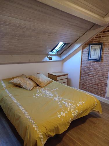 une chambre avec un lit dans un grenier dans l'établissement La Maison Bleue - Domaine de la Garanne, à Savignac-Lédrier
