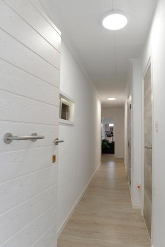a hallway with white walls and a door at La coqueta in Murcia