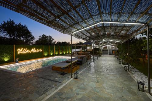 einen Pool mit einer Pergola neben einem Gebäude in der Unterkunft Villa Mairi in Salamís