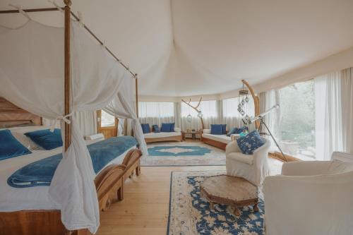 1 dormitorio con cama con dosel y sala de estar. en E-glamping/Blue Saphir Tent, en Arezzo