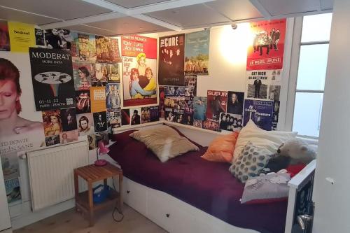Cette chambre comprend un lit avec des affiches murales. dans l'établissement Originale maison individuelle au coeur de Paris !, à Paris