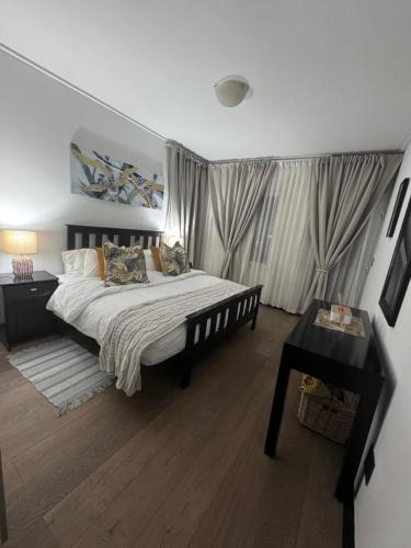 Un dormitorio con una cama grande y una mesa. en @Liam Flatrock, en Ciudad del Cabo