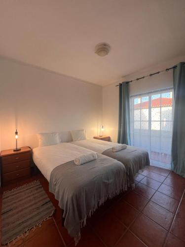 ein Schlafzimmer mit einem großen Bett und einem Fenster in der Unterkunft Escape House in Almograve