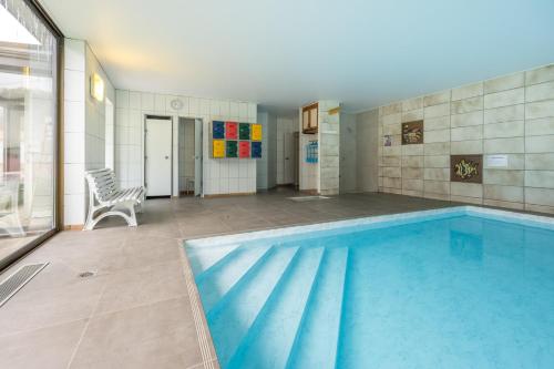 a large swimming pool in a room with at Logis Hostellerie Motel Au Bois Le Sire in Orbey