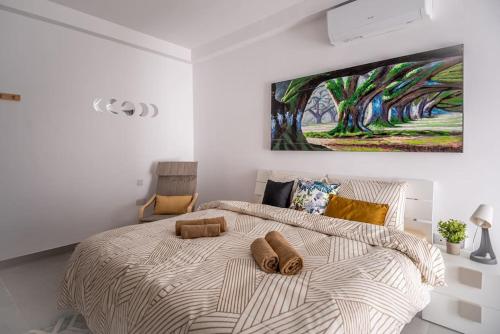 a bedroom with a bed with a painting on the wall at LA88 Cityway Apartment 5 in Il-Gżira