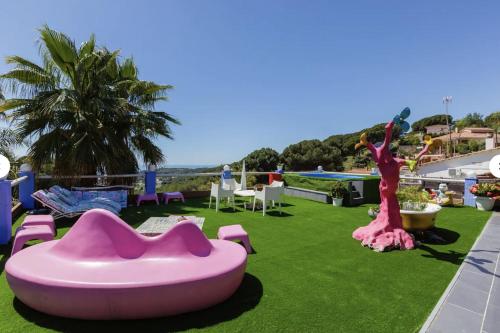 een resort met een zwembad en een groot roze meubilair bij Casa Miramiranda in Teià