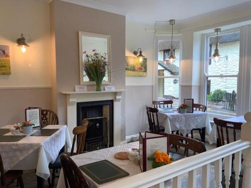a dining room with two tables and a fireplace at Whortleberry Studio B & B in Porlock