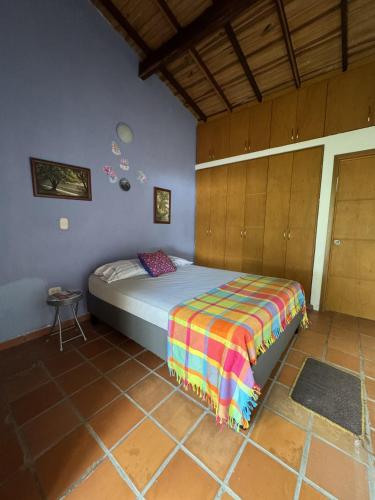 a bedroom with a bed with a colorful blanket at Hermosa Cabaña Campestre en Chinacota in Chinácota