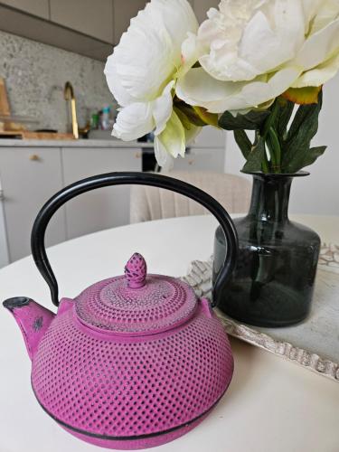 a pink tea pot and a vase with white flowers at Il Vento in Split