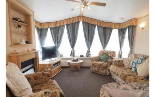 a living room with a couch and a tv at Cliffs of Moher Hideaway in Liscannor