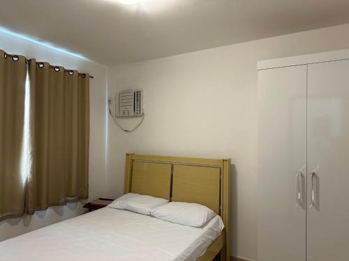 a small bedroom with a bed and a shower at Apartamento em Condomínio Marinas Clube in São Pedro da Aldeia