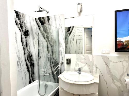a bathroom with a sink and a toilet and a tub at CitizenA Studio no smoking in Radom