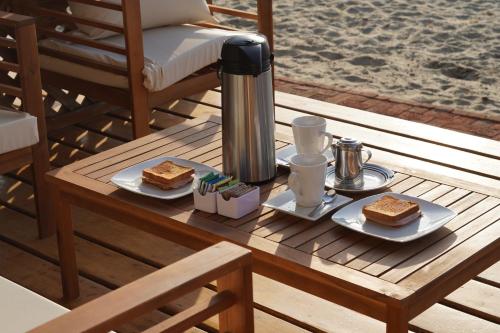 une table en bois avec deux assiettes de nourriture dans l'établissement Hotel Gran Azul Bungalows, à Canoas de Punta Sal