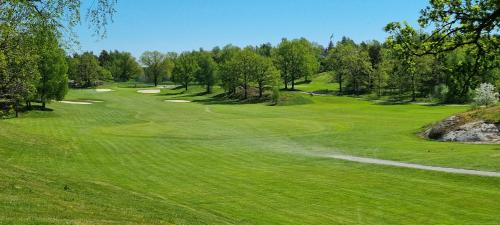 a view of a green golf course with trees at Villa Strömma Värmdö - Sthlm archipelago, comfortable & fully equipped, 35 min from city center in Värmdö