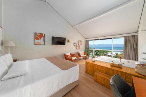 um quarto de hotel com uma cama e uma banheira em Pousada dos Sonhos em Florianópolis