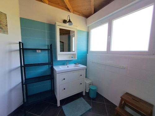 une salle de bain avec un lavabo et un miroir dans l'établissement Bois d'été, à Saint-Julien-en-Born