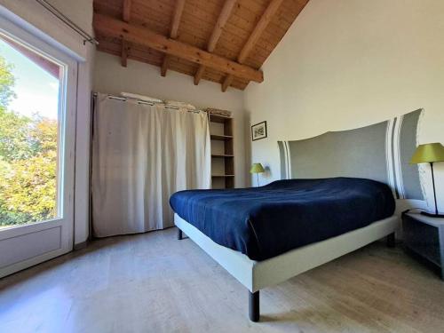 une chambre avec un lit et une grande fenêtre dans l'établissement Bois d'été, à Saint-Julien-en-Born