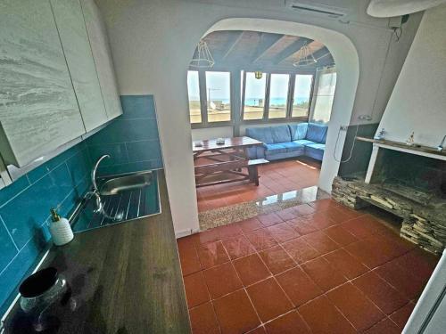 eine Küche mit einem Wohnzimmer mit einem Kamin in der Unterkunft Casa La Pelosa in Stintino