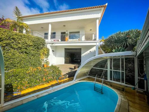 una piscina di fronte a una casa di Indigo Star House a Ribeira Brava