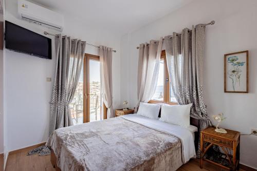 a bedroom with a bed and a large window at Villa Chara in Ammouliani