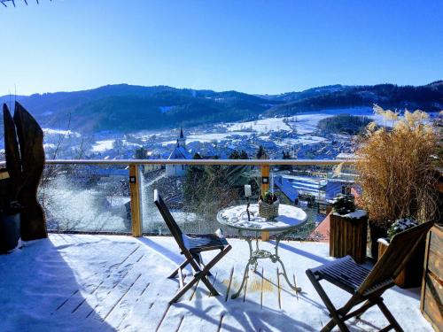 a balcony with a table and chairs and a view of a city at Chata s wellness in Hutisko