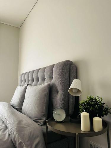 Una sala de estar con un sofá y una mesa con una lámpara. en Milastos apartamentai, en Birštonas