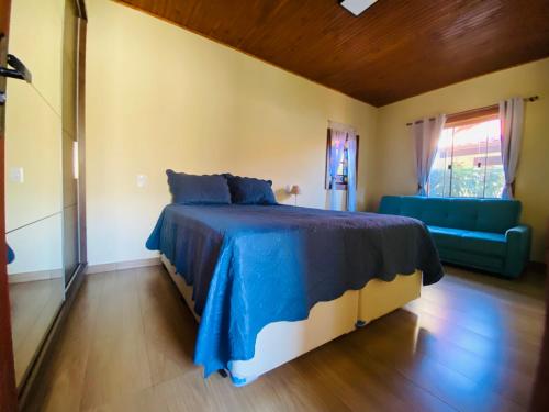 蒂拉登蒂斯的住宿－“Recanto Pingo de Ouro”，一间卧室配有蓝色的床和蓝色的沙发