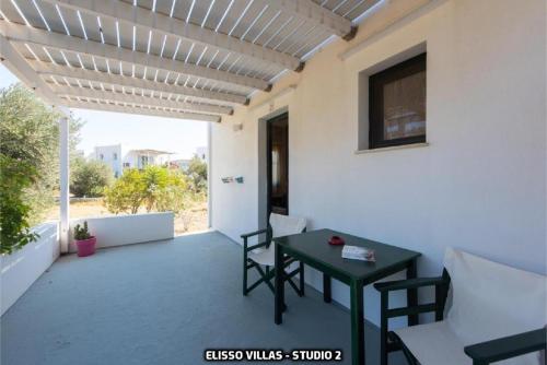 a patio with a table and chairs on a balcony at Elisso Villas in Platis Yialos Sifnos